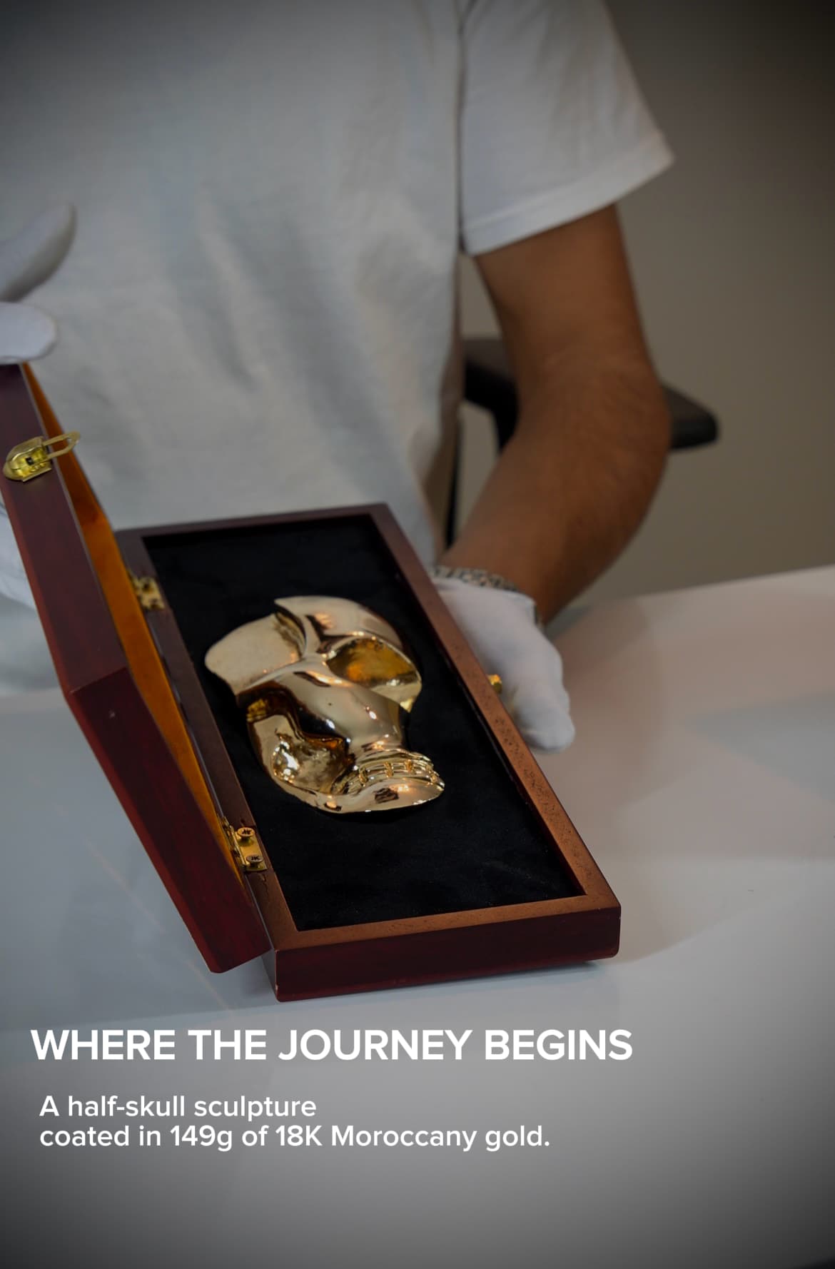 The gold sculpture displayed open in a velvet-lined presentation case.